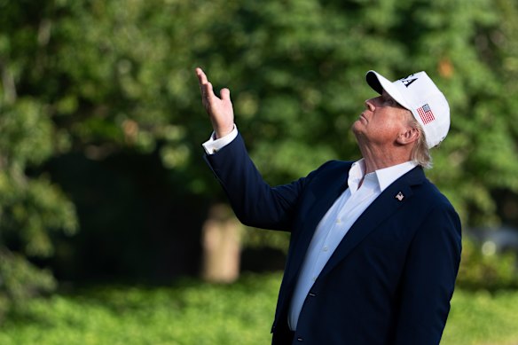 US President Donald Trump looks up at the American flag outside the White House on Sunday.