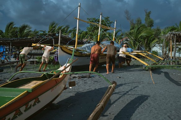 Fisherman bring a boat back to shore near the Bataan Nuclear Power Plant.