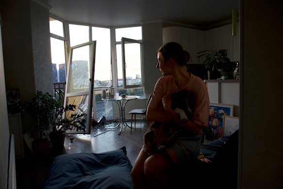 Julia Sosnovska hugs her dog Perry inside her apartment in the Lukianivka neighbourhood of Kyiv, Ukraine, the morning after it was damaged by a Russian attack.