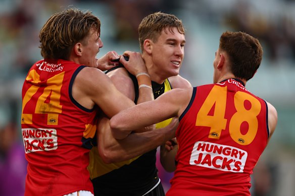Lynch wrestles with Crows Josh Worrell and Mark Keane.