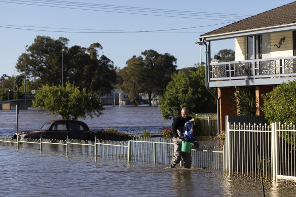 Whitmouth devant sa maison inondée. 