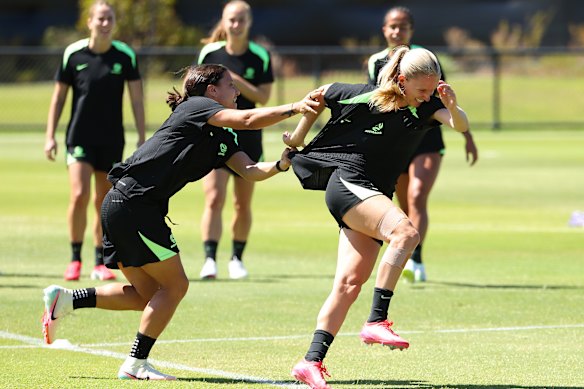 Sam Kerr and Kaitlyn Torpey have fun during the warm-up drill at Matildas training on Saturday.