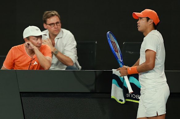 Learner Tien talks to his coaching staff during his quarter-final match