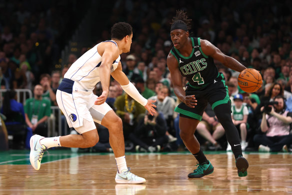 Jrue Holiday #4 of the Boston Celtics dribbles the ball against Josh Green #8 of the Dallas Mavericks.
