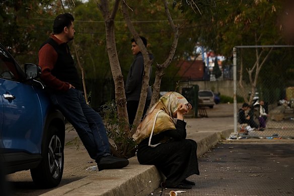 A woman sits crying on a kerb  at a shelter at the Quarantina near the Port of Beirut.