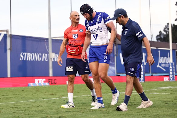 Matt Burton is helped off the field at Belmore Oval.
