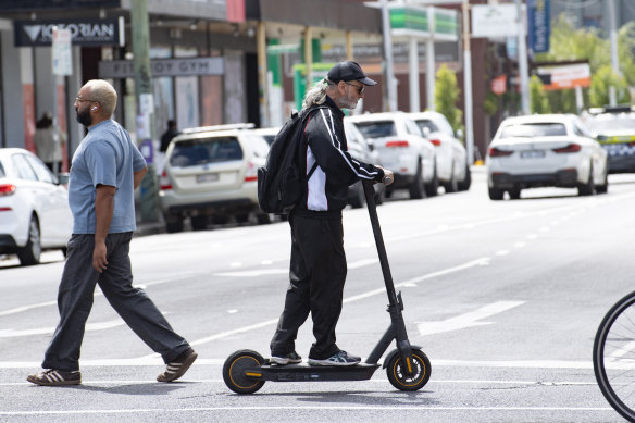 A man rides an electric scooter in Melbourne.