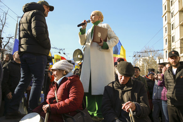 Des manifestants âgés se reposent sur un podium tandis que Marina Tauber, vice-présidente du Parti Shor, ami de la Russie, prend la parole lors d'une manifestation initiée par le Mouvement pour le peuple et son parti, contre le gouvernement pro-occidental et le niveau de vie à Chisinau, la capitale.
