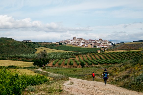 Pilgrims walking toward the old village in Cirauqui, Navarra, Spain.