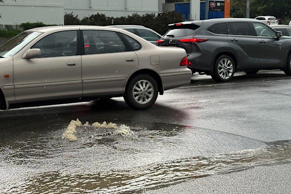 Water overflows from a drain on a road in Indooroopilly after Monday’s storm.