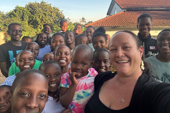 Carley Mchome pictured in 2025 with residents of the Ujamaa children’s home.