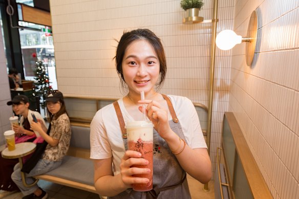Gotcha Tea staffer Nadia with a strawberry macchiato cheese tea at a Melbourne CBD location.