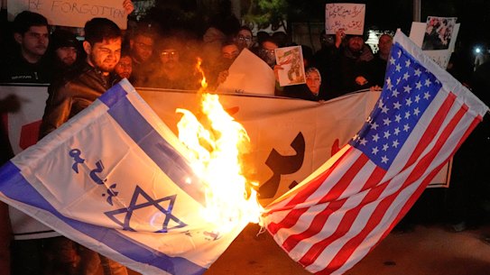 Pro-government protesters burn US and the Israeli flags in Tehran, Iran, on Wednesday, 
