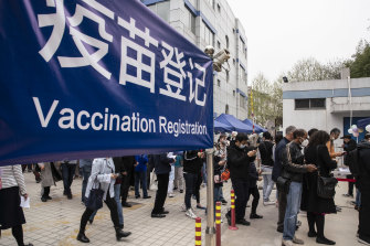 Des gens attendent devant un centre de vaccination COVID-19 pour ressortissants étrangers à Shanghai, en Chine.