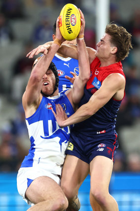 Tristan Xerri of the Kangaroos marks in front of Trent Rivers of the Demons.