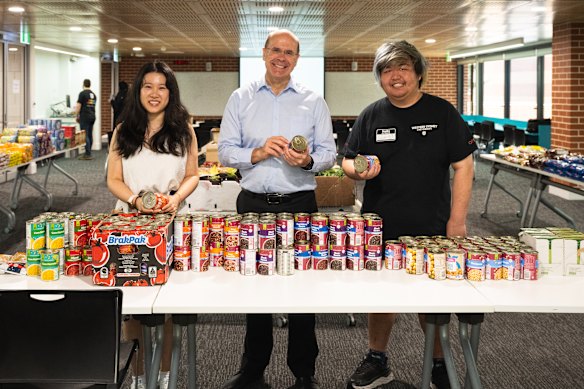 Vice chancellor George Williams at the food pantry with student community program coordinator Miranda Zhang (left), and student Richard Xu. 