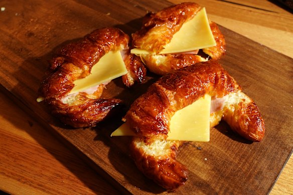 Argentinian croissants are glazed with apricot jam and filled with ham and cheese.