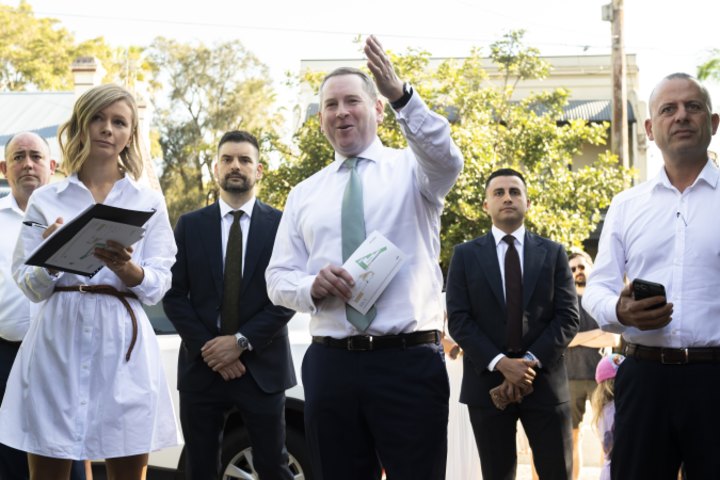 Auctioneer Edward Riley (centre) and selling agent Joseph Tropiano (right) at the auction for the Petersham home.
