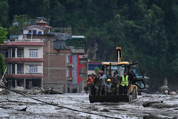 Rescuers use an excavator to save survivors in Nepal.