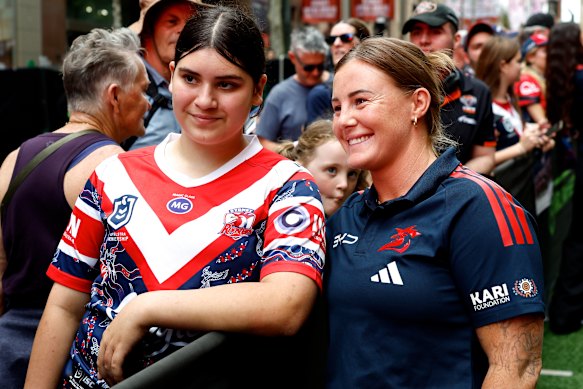 Roosters winger Jayme Fressard takes a photo with a fan.