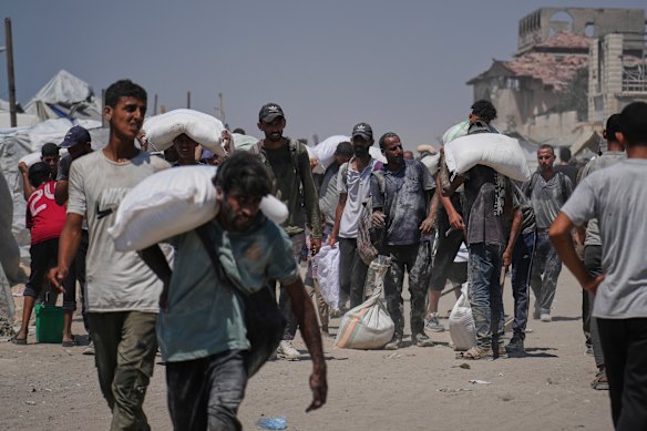 Os palestinos na Palestina administram sacos de pó não controlados para ajudar a seguir a ajuda da Gaza.