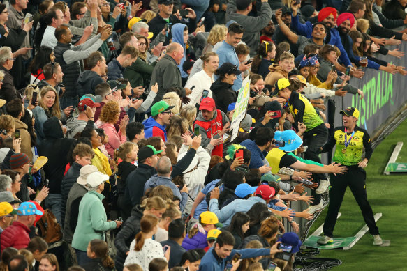 Molly Strano climbs into the crowd at the T20 World Cup final in 2020.