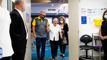 Le Premier ministre Scott Morrison accompagne Jane Malaysiak, la première personne à se faire vacciner contre le coronavirus en Australie, pour obtenir sa deuxième dose.