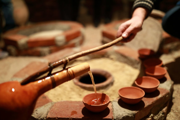 Pouring vino  from a qvevri (earthenware vas  utilized  for fermentation) utilizing an orshimo (traditional ladle).