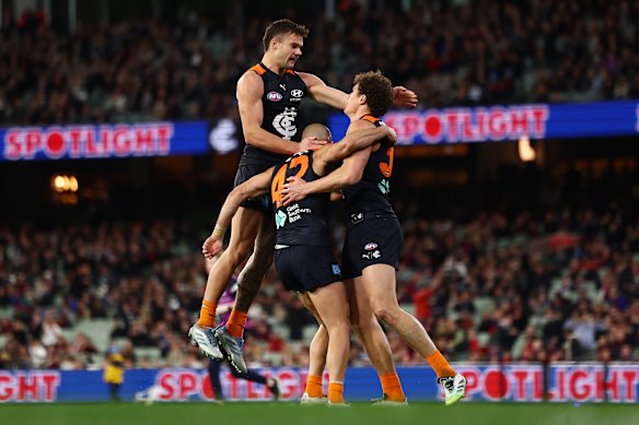 Carlton teammates mob Charlie Curnow after he kicked the sealer.