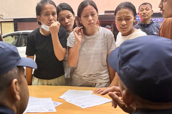 Kabita Tamang, wearing black, and family members try to find their relatives at a hospital in Kathmandu. 