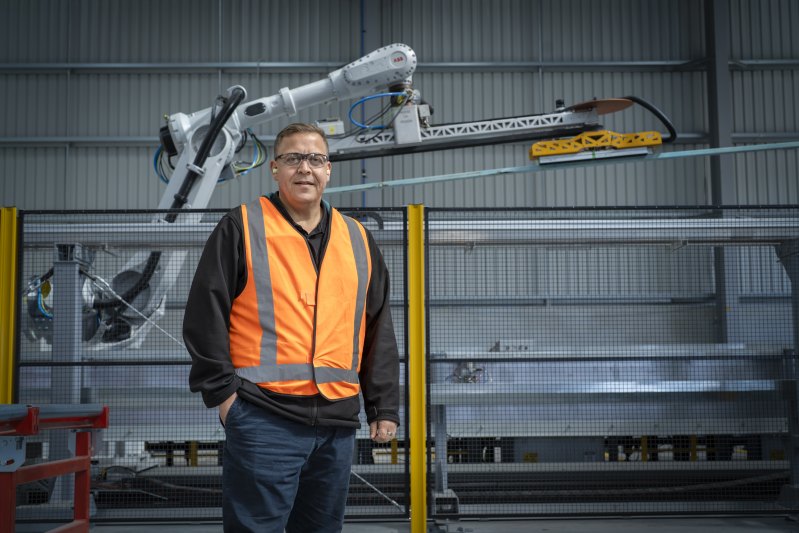 Arm’s length assembly: Ben McIntosh, Bunnings’ chief operating officer for commercial, with a robotic arm that is part of the company’s new automated roof truss system.
