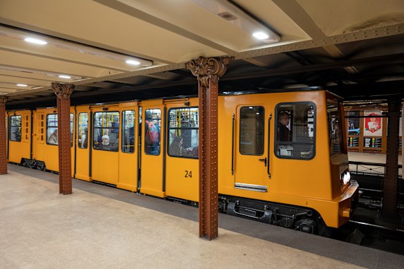 One of Budapest’s distinctive yellow Line 1 metro trains at the platform of Opera underground station.