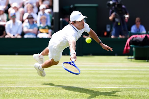 Alex de Minaur gets airborne to hit a volley during his four-set win over Zach Svajda.