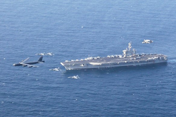 The USS Abraham Lincoln and an Air Force B-52H conduct joint exercises in the Arabian Sea in 2019.