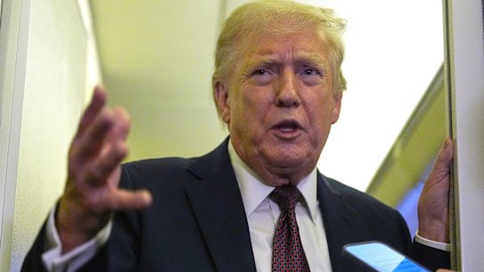 US President Donald Trump speaks to reporters aboard Air Force One.