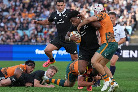 Fraser McReight (white headgear) makes a tackle on Peter Lakai in Sydney on Saturday.