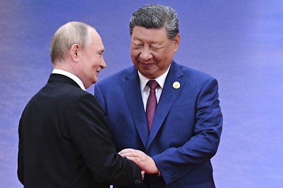Russian President Vladimir Putin, left, and Chinese President Xi Jinping greet each other.
