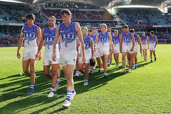 Larkey leads the dejected Roos off Adelaide Oval.