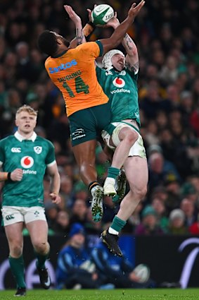 Filipo Daugunu of Australia jumps for the ball with Mack Hansen.