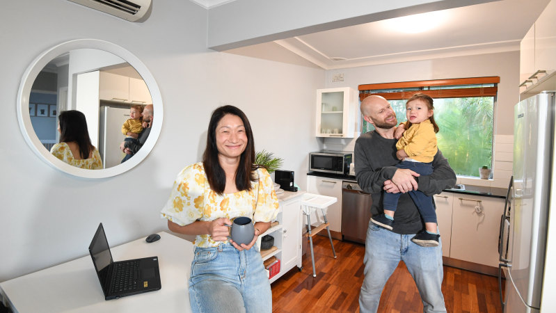 Kim Lam and her partner Dru Rustin holding son Oliver. They are selling their two-bedroom unit because they have outgrown it.