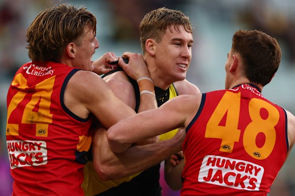 Lynch wrestles with Crows Josh Worrell (left) and Mark Keane.