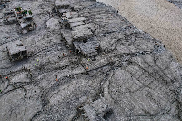 A drone view shows rescue workers inspect the area and damaged structures in Nepal.