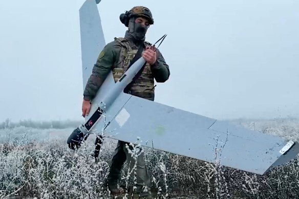 A Russian soldier carries a drone to launch in an undisclosed location in Ukraine.