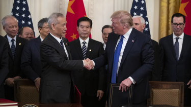 President Donald Trump and Chinese Vice Premier Liu He shake hands after signing the US-China trade agreement in the White House.
