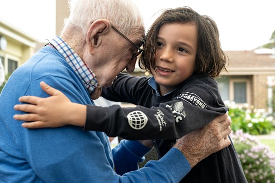  Flynn Sullivan, 7, gives great-buppa Reverend Bill Morgan a hug at a family barbecue.