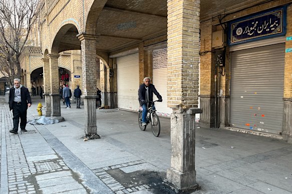 A man rides his bicycle past shops that have been closed during protests in Tehran’s centuries-old main bazaar earlier this week.
