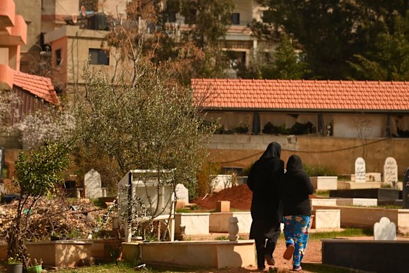 A week after the March 6 attack, an explosion thunders across Nabi Chit, startling a woman and her daughter as they tend to one of the graves.