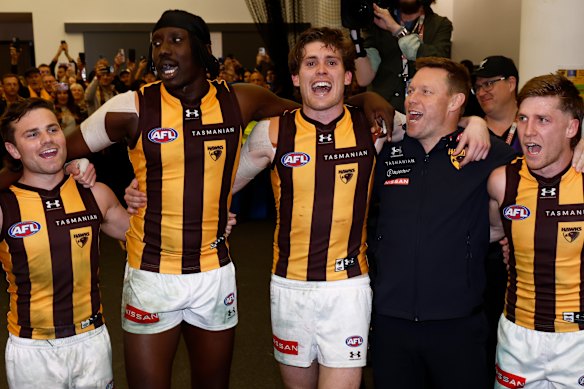 Day (centre) sings the Hawks’ famous song alongside Nick Watson, Mabior Chol, coach Sam Mitchell, and Dylan Moore.