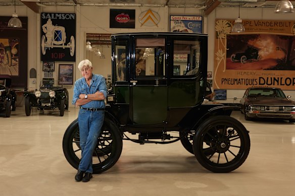 Jay Leno with a restored 1909 Baker Electric at a facility for his large automobile collection in Burbank, California.