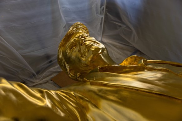 The golden Trump statues rests beneath its protective tent. 